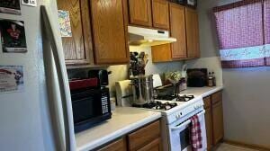 kitchen featuring refrigerator and white range with gas stovetop