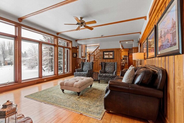 2532 Huntington Way, Suamico, WI 54173 - living room featuring wooden walls, hardwood / wood-style floors, a ceiling fan, and stairs