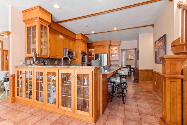 2532 Huntington Way, Suamico, WI 54173 - kitchen with a sink, wainscoting, a peninsula, glass insert cabinets, and appliances with stainless steel finishes
