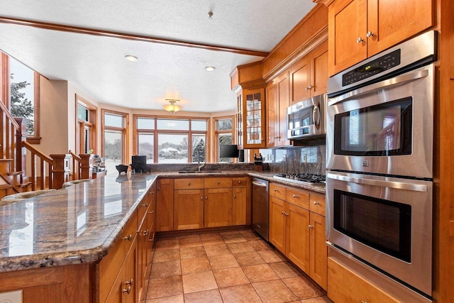 2532 Huntington Way, Suamico, WI 54173 - kitchen with brown cabinetry, a peninsula, stainless steel appliances, and a textured ceiling