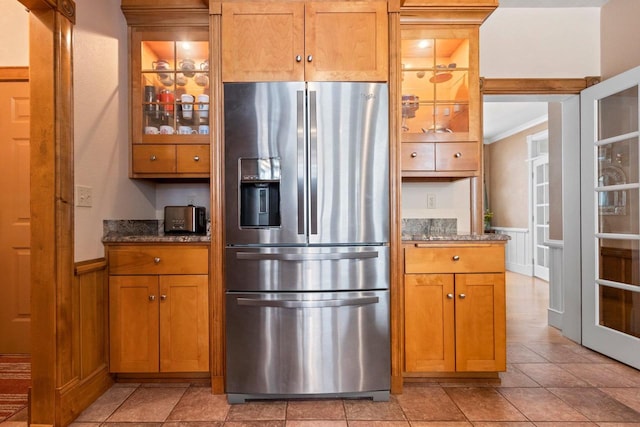 2532 Huntington Way, Suamico, WI 54173 - kitchen featuring glass insert cabinets, dark stone countertops, a wainscoted wall, and stainless steel fridge with ice dispenser