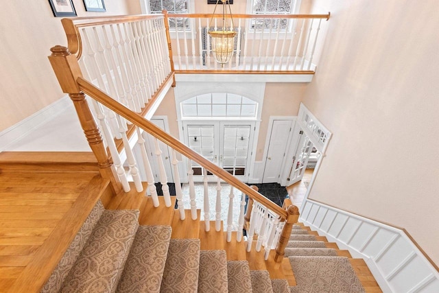 2532 Huntington Way, Suamico, WI 54173 - stairway featuring wood finished floors, a towering ceiling, and an inviting chandelier