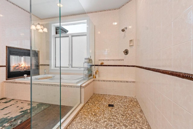 2532 Huntington Way, Suamico, WI 54173 - bathroom featuring tile patterned floors, a bath, tile walls, a tile fireplace, and tiled shower