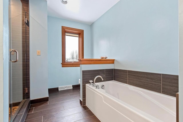 2532 Huntington Way, Suamico, WI 54173 - bathroom with visible vents, toilet, a bath, baseboards, and a stall shower
