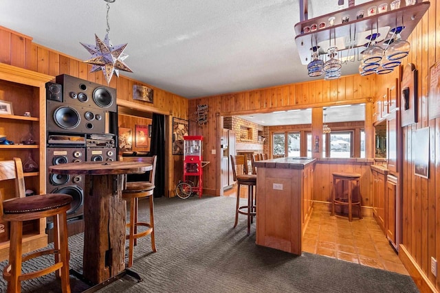 2532 Huntington Way, Suamico, WI 54173 - bar featuring a bar, a textured ceiling, a chandelier, light carpet, and wood walls