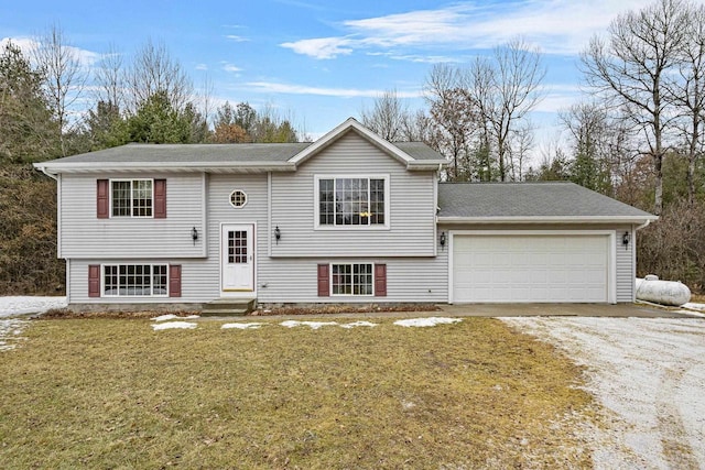 bi-level home with a garage and a front lawn