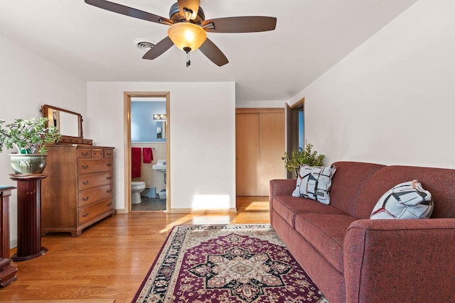 living room featuring ceiling fan and light wood-type flooring