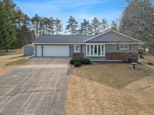 single story home with a garage and a front lawn