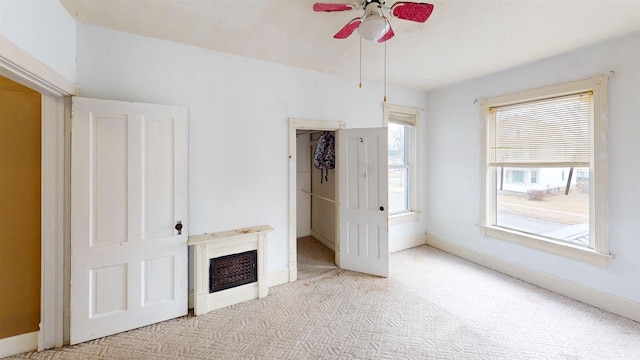 unfurnished living room featuring light colored carpet and ceiling fan