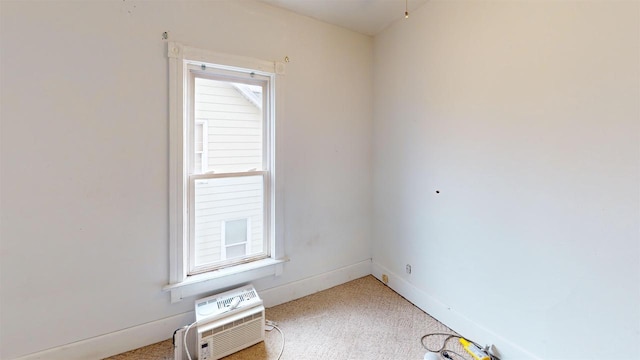 carpeted empty room with an AC wall unit