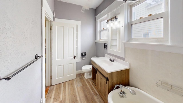 bathroom featuring vanity, hardwood / wood-style floors, a bathtub, and toilet