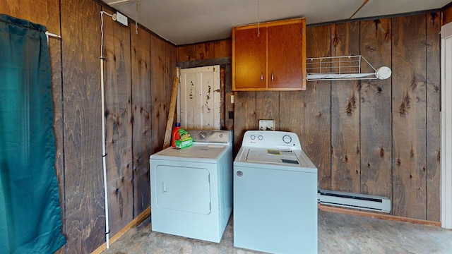 clothes washing area with cabinets, a baseboard heating unit, separate washer and dryer, and wood walls