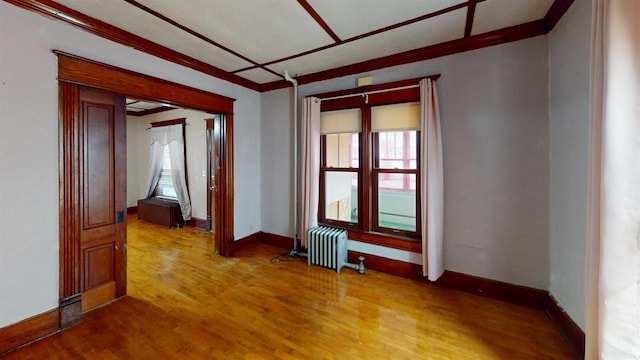 spare room with hardwood / wood-style floors, a wealth of natural light, and radiator heating unit