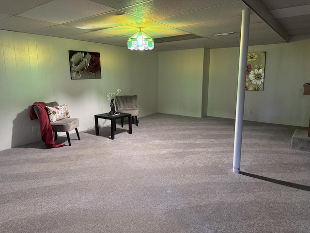 sitting room featuring carpet flooring and a drop ceiling