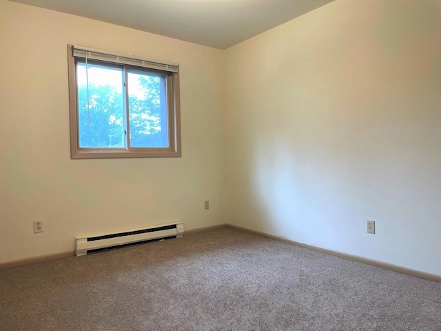 carpeted empty room featuring a baseboard heating unit