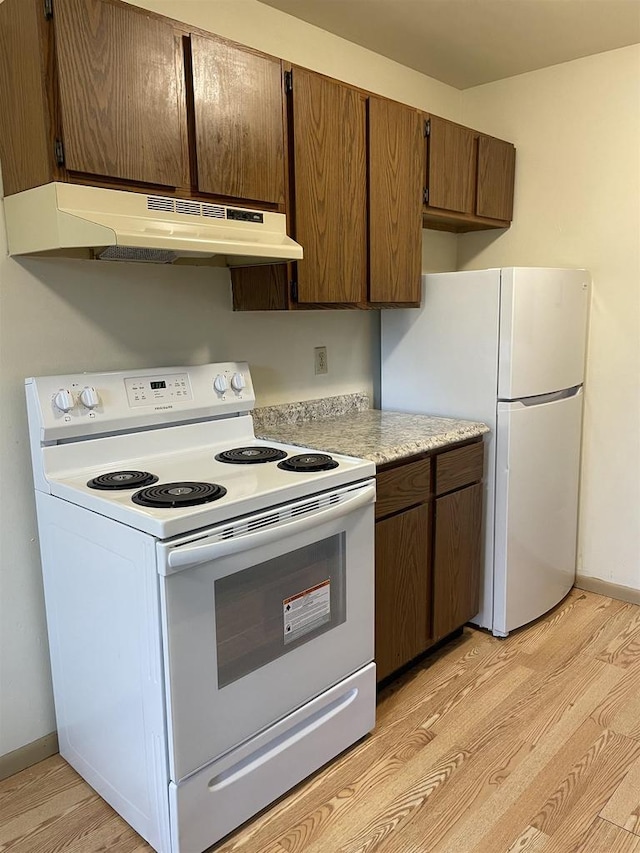 kitchen with white appliances and light hardwood / wood-style floors