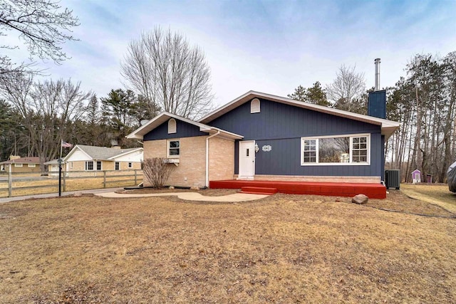 view of front of property featuring a front yard and central air condition unit