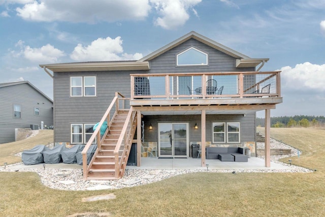 back of property with a wooden deck, a lawn, and a patio area