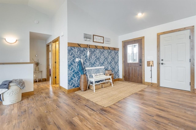 foyer featuring wood-type flooring and high vaulted ceiling