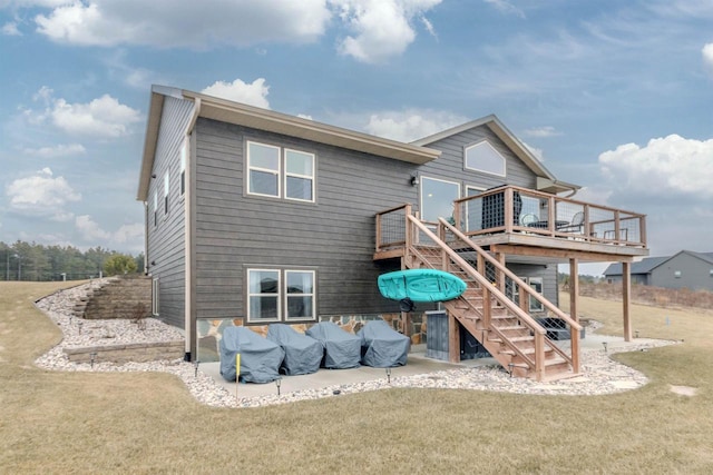 rear view of house featuring a wooden deck, a patio, and a lawn