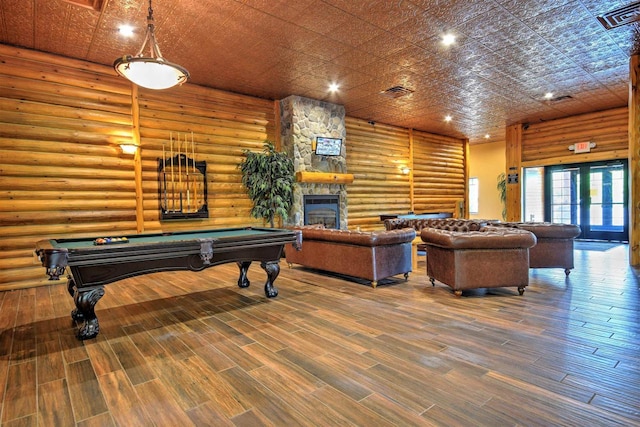 playroom with hardwood / wood-style floors, pool table, a fireplace, and rustic walls