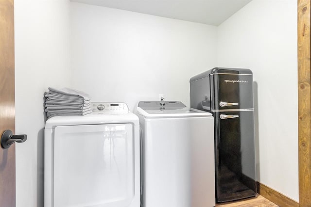 clothes washing area featuring washing machine and dryer and light hardwood / wood-style floors