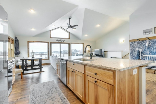 kitchen featuring light brown cabinetry, sink, wood-type flooring, stainless steel dishwasher, and a kitchen island with sink