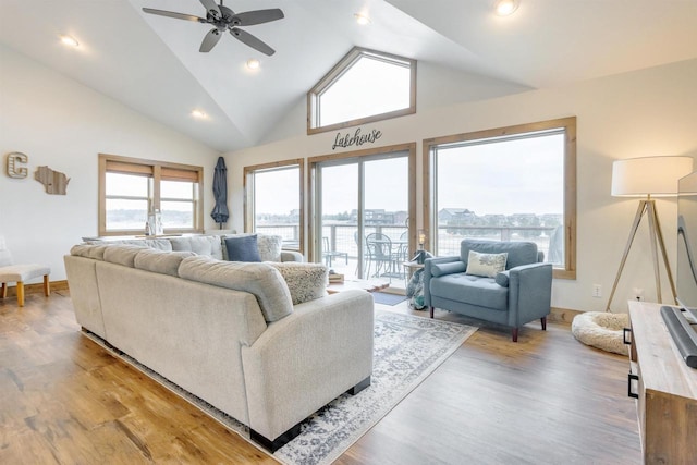 living room featuring wood-type flooring, high vaulted ceiling, and ceiling fan