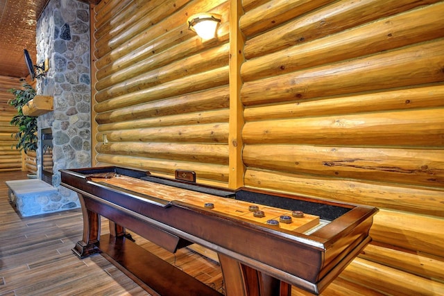 recreation room with dark hardwood / wood-style floors and rustic walls