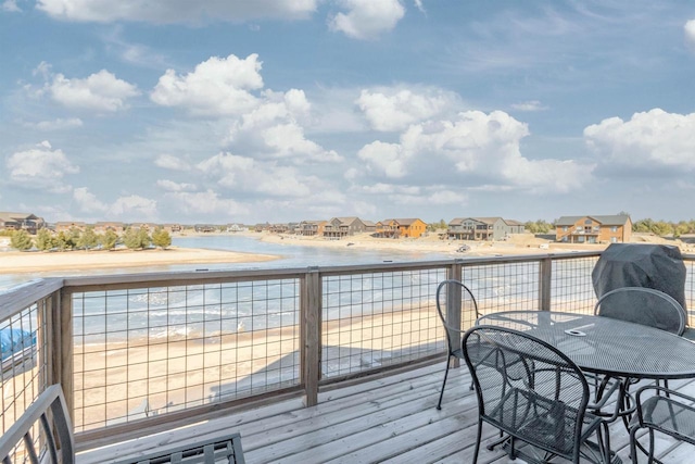 wooden deck featuring a water view and a view of the beach