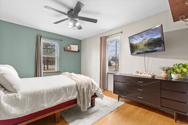 bedroom with light hardwood / wood-style flooring and ceiling fan