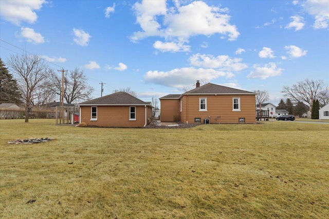 rear view of property featuring a yard