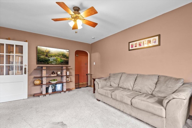 carpeted living room with ceiling fan