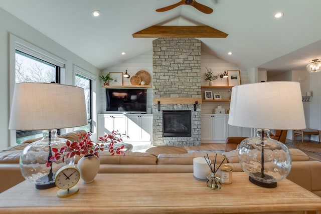 living room with ceiling fan, a fireplace, light hardwood / wood-style floors, and vaulted ceiling