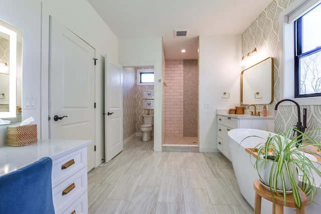 bathroom with vanity, toilet, and a tile shower