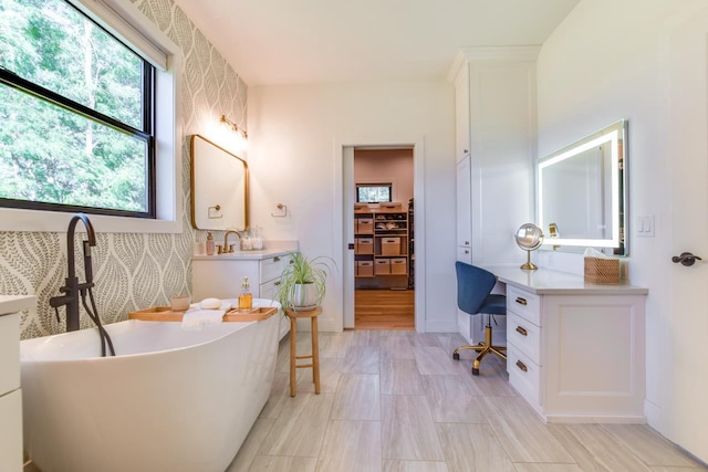 bathroom featuring vanity and a washtub