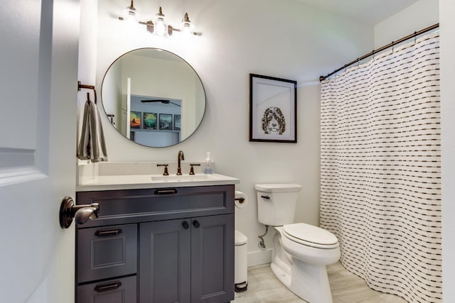 bathroom with vanity, curtained shower, wood-type flooring, and toilet