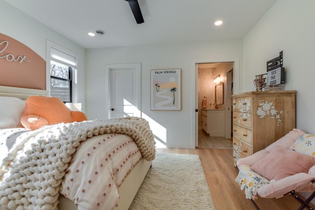 bedroom with ceiling fan, connected bathroom, and light hardwood / wood-style floors