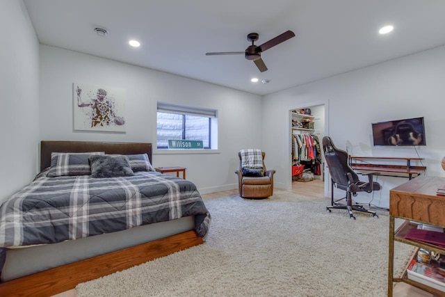 carpeted bedroom featuring ceiling fan, a spacious closet, and a closet