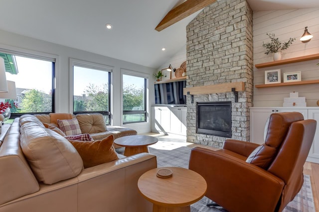 living room featuring light hardwood / wood-style flooring, beam ceiling, a fireplace, and high vaulted ceiling