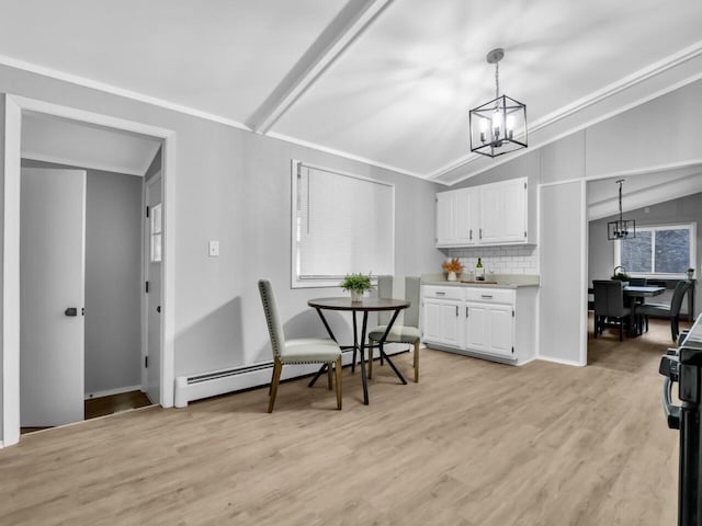 dining space with vaulted ceiling, a baseboard heating unit, an inviting chandelier, and light hardwood / wood-style flooring