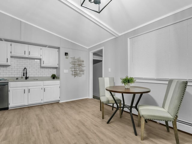 kitchen featuring white cabinetry, lofted ceiling, sink, and light hardwood / wood-style flooring