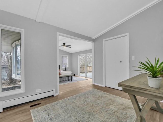 foyer entrance with hardwood / wood-style flooring, vaulted ceiling, and baseboard heating