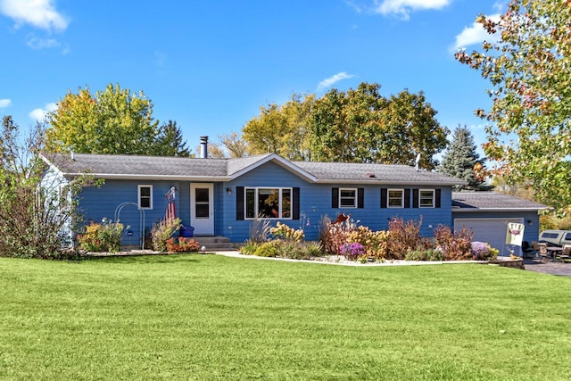 ranch-style house featuring a garage and a front lawn