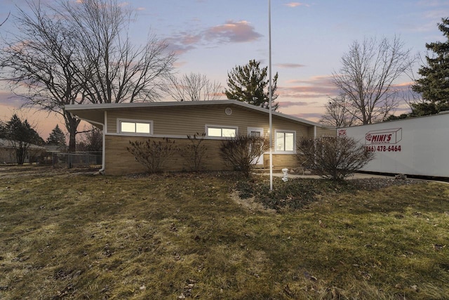 property exterior at dusk with a lawn