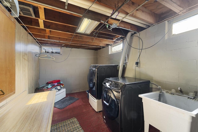 washroom with a wealth of natural light, washer and dryer, and sink