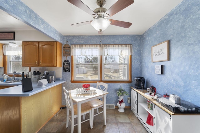 kitchen with sink, light tile patterned floors, ceiling fan, and kitchen peninsula