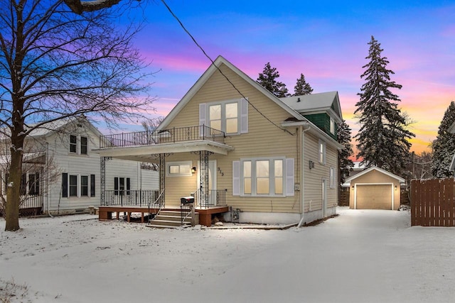 view of front property with an outbuilding, a garage, and a balcony