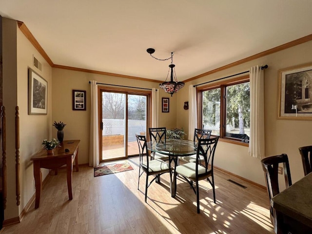 dining space featuring ornamental molding, plenty of natural light, and light hardwood / wood-style floors