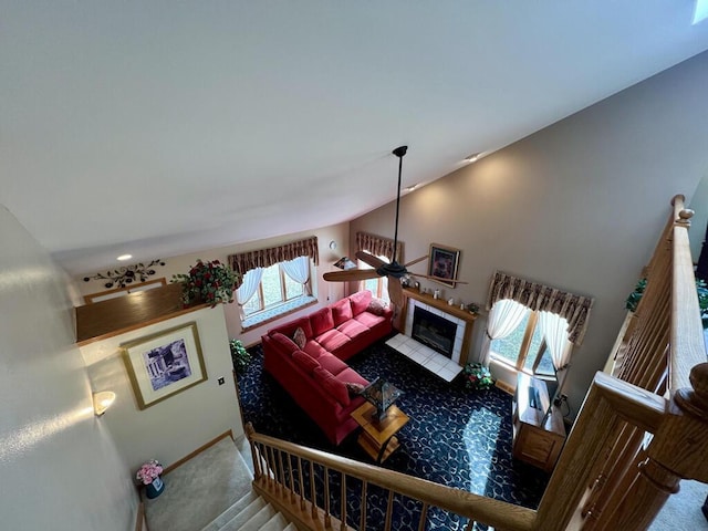 living room with lofted ceiling, carpet flooring, and a tile fireplace